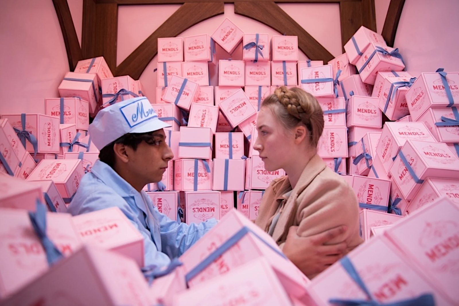 A frame from The Grand Budapest Hotel showing the hotel's colour palette, symmetrical interior and staff uniforms.